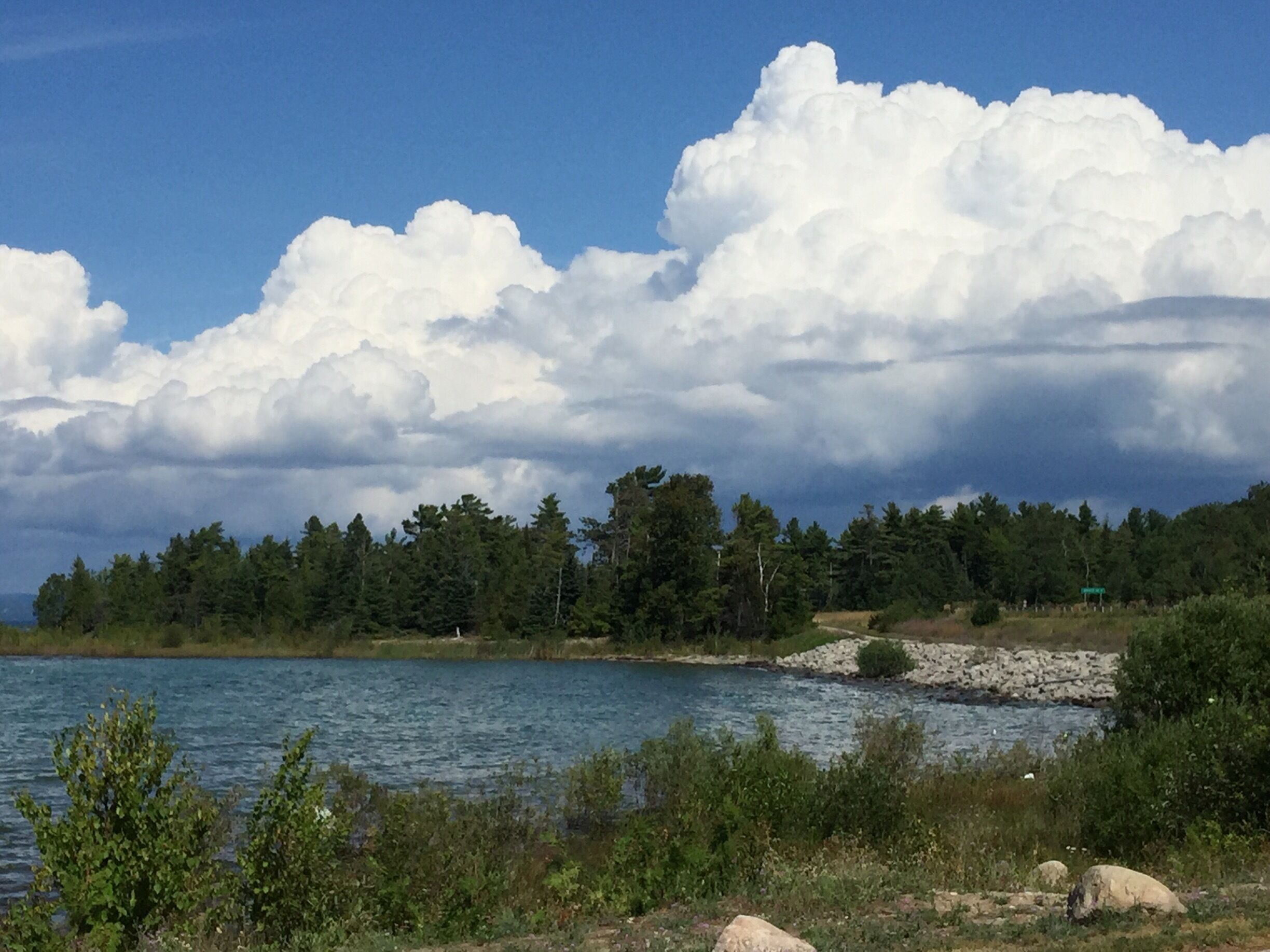 A beautiful day of blue skies and white fluffy clouds in Upper Michigan. The water of Lake Michigan is so clear and blue.