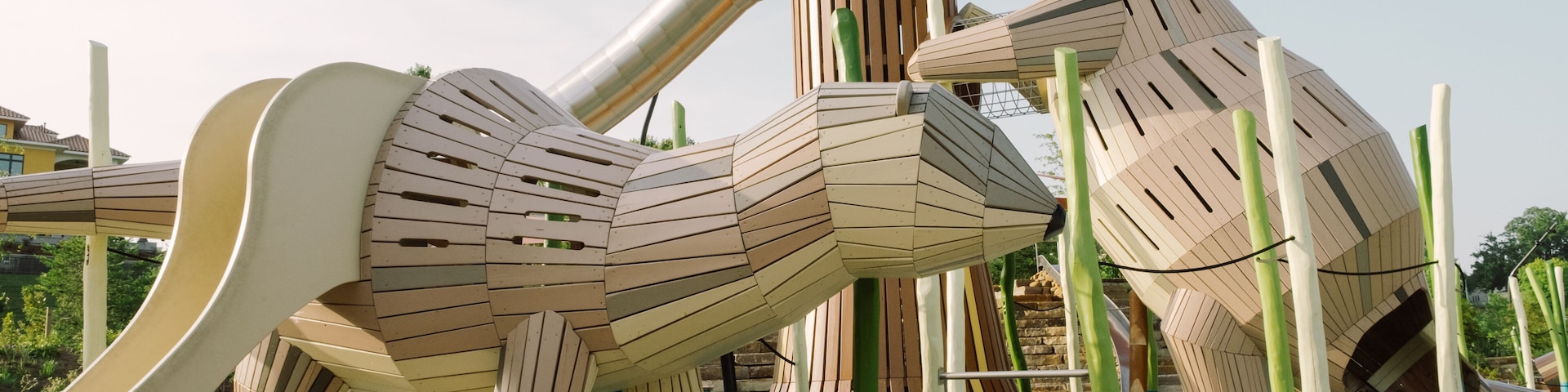 A playground with wooden structures resembling animals, including a giraffe and a bear.