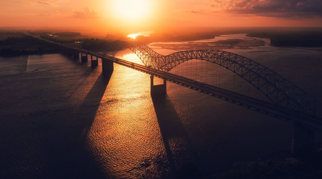 Bird's eye view of Memphis Bridge connecting Tennessee and Arkansas at sunset over Mississippi River