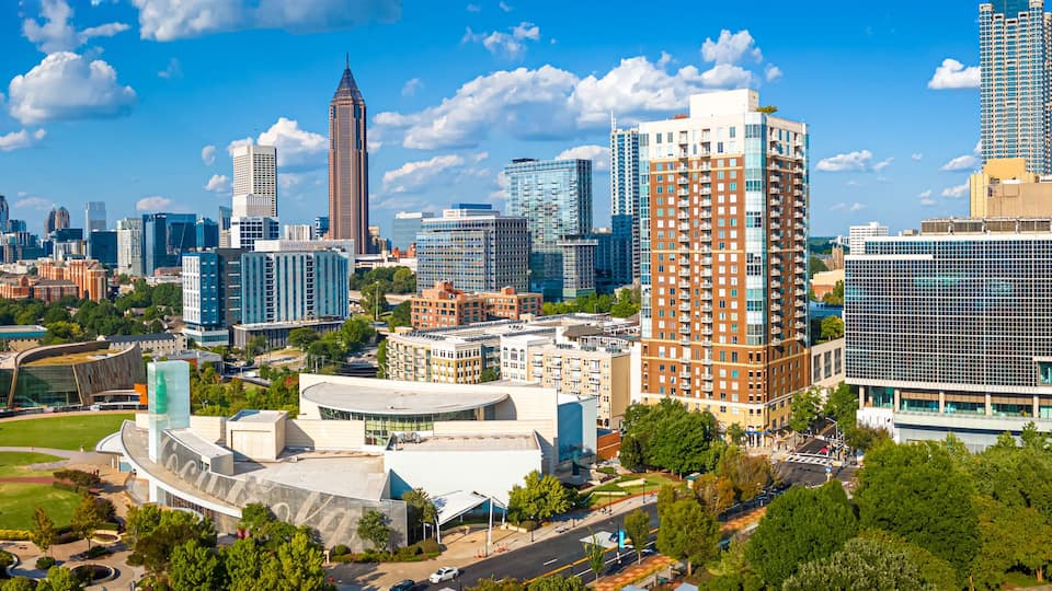 A cityscape with modern architecture, including a distinctive curved building and a tall skyscraper.