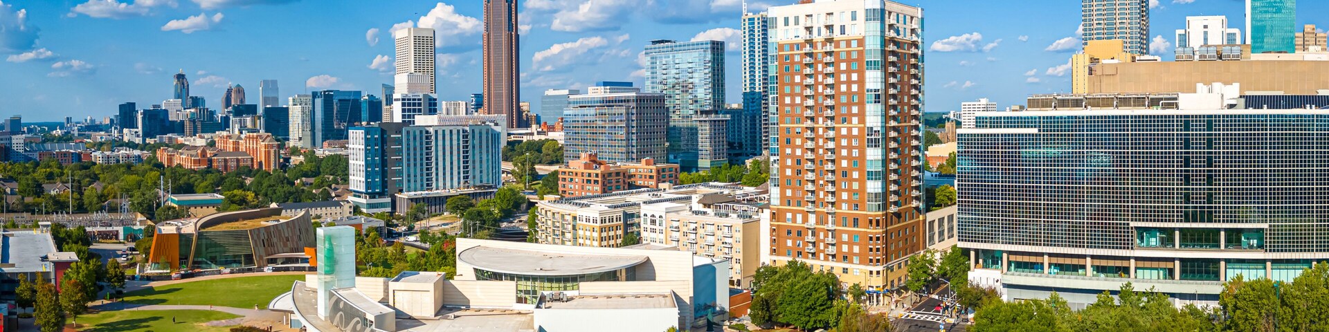 Paisagem urbana com arquitetura moderna, incluindo um edifício curvo marcante e um arranha-céu imponente.