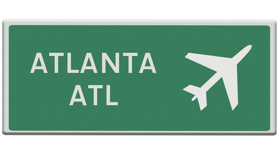 A green sign with 'ATLANTA ATL' and an airplane symbol.
