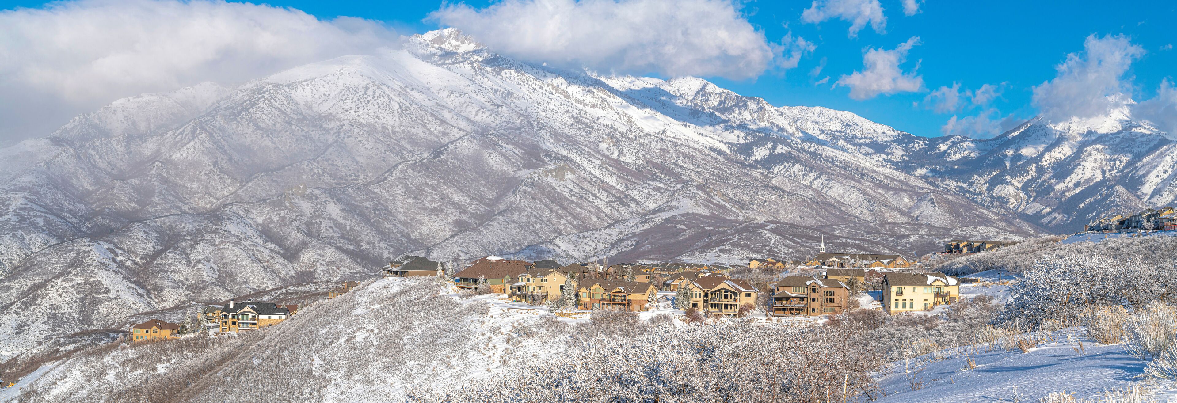 A snow-covered mountain range with a town nestled at its base.