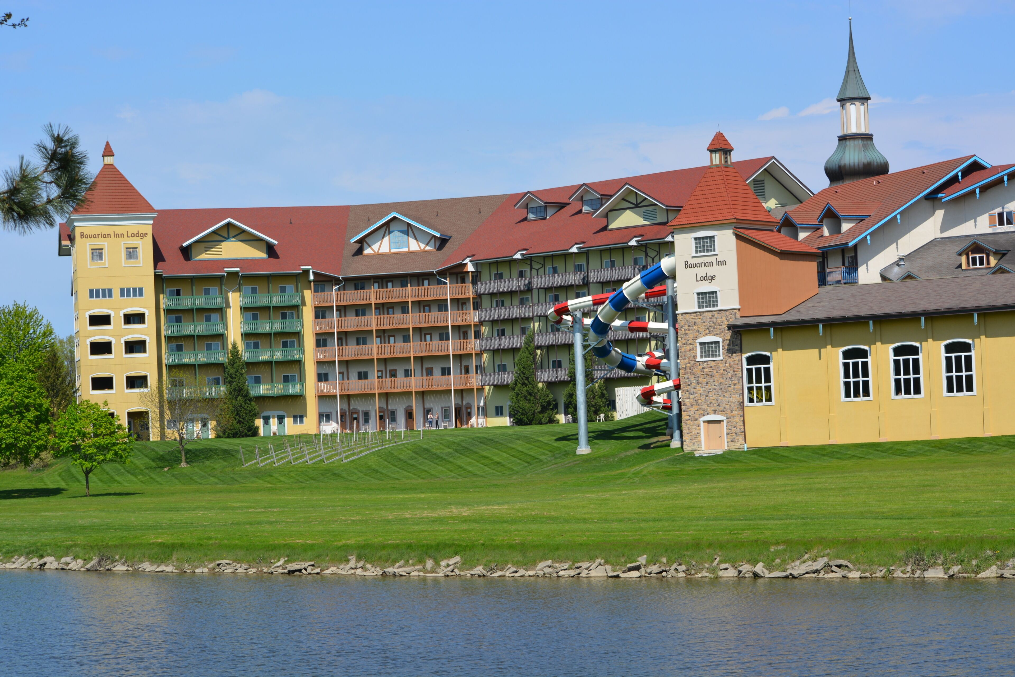 Un hotel Bavarian Inn Lodge con techo rojo, varios balcones y una torre.