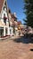 A cobblestone street lined with traditional European buildings, including a shop named "Cats & Dogs."