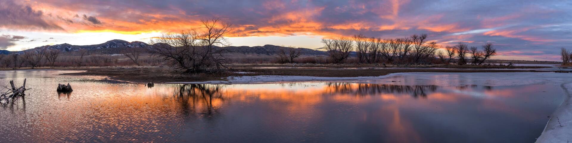 Sunset Winter Lake - A colorful winter sunset at a half-frozen bay of a mountain lake. Chatfield State Park, Denver-Littleton, Colorado, USA.