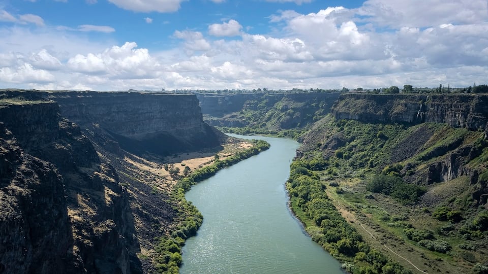 A river winding through a canyon with steep cliffs and sparse vegetation.