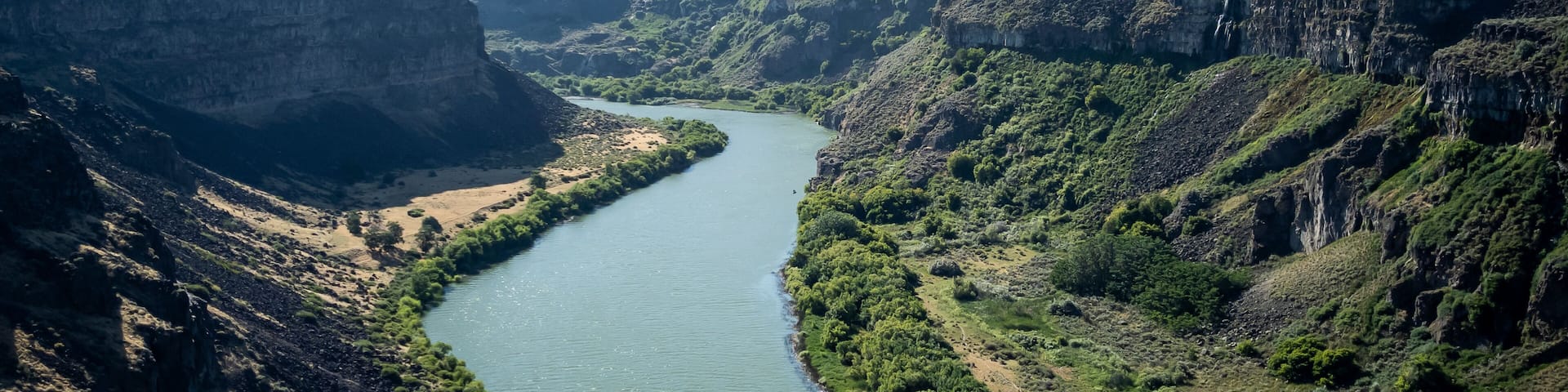 Winding Snake River flowing thru the pacific northwest in the summertime on a partly cloudy day