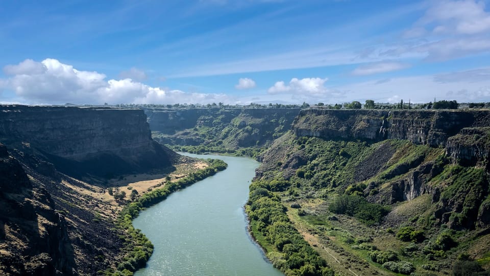 A river winding through a canyon with steep cliffs and sparse vegetation.
