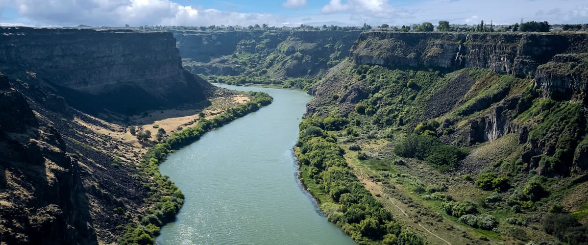 A river winding through a canyon with steep cliffs and sparse vegetation.
