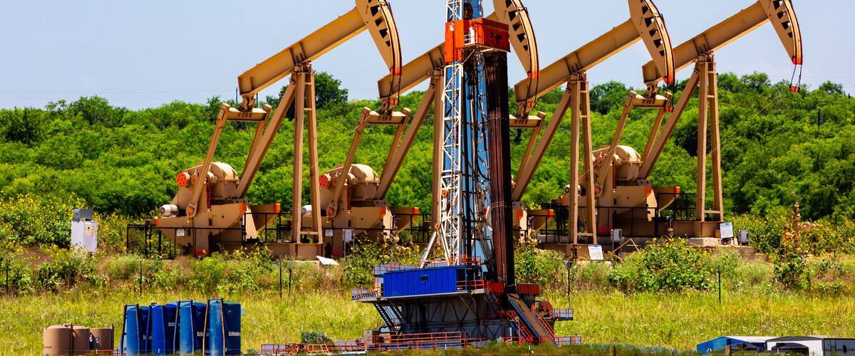 Composite of pump jacks and drilling platform, Karnes County, Texas.