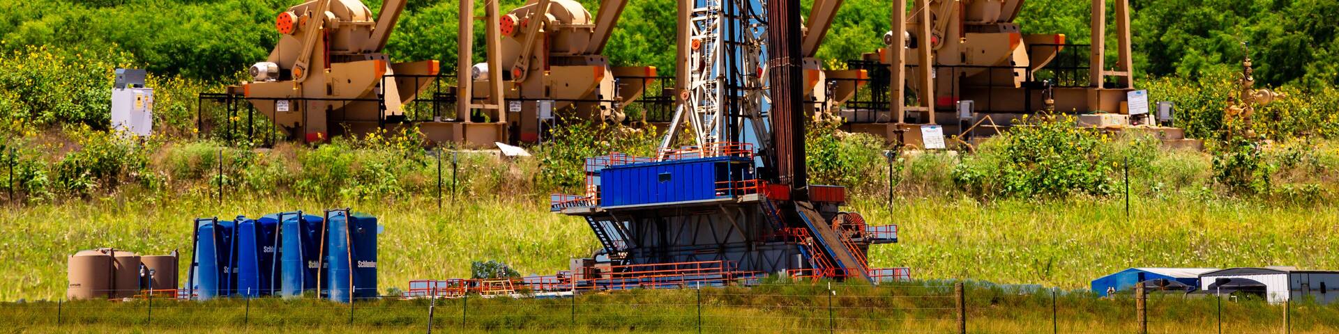 Composite of pump jacks and drilling platform, Karnes County, Texas.