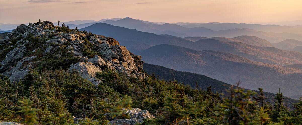 A mountain landscape with rocky outcrops and dense forest.
