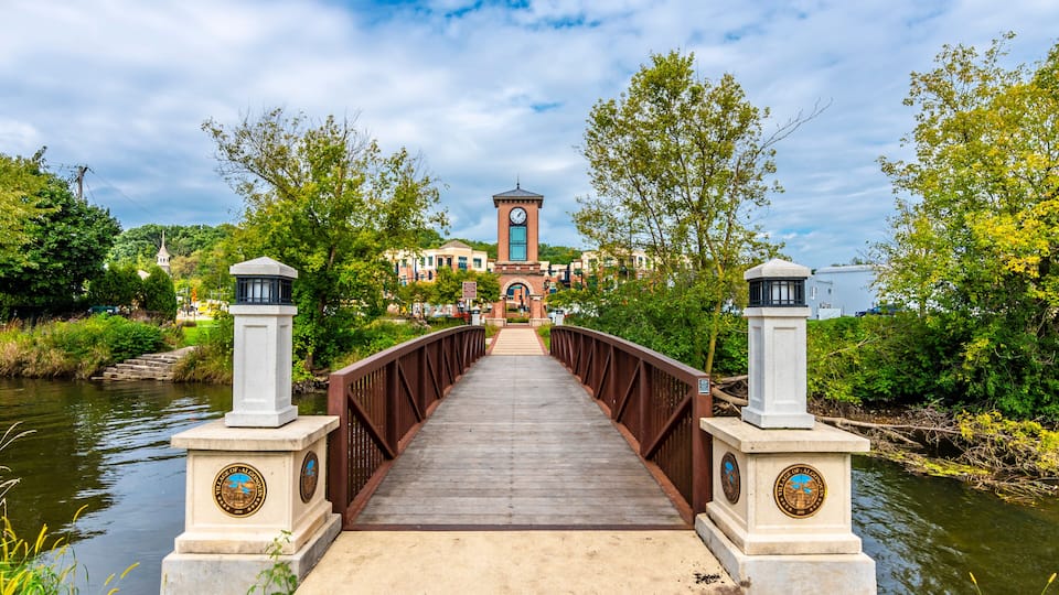 A wooden bridge with a clock tower in the background.