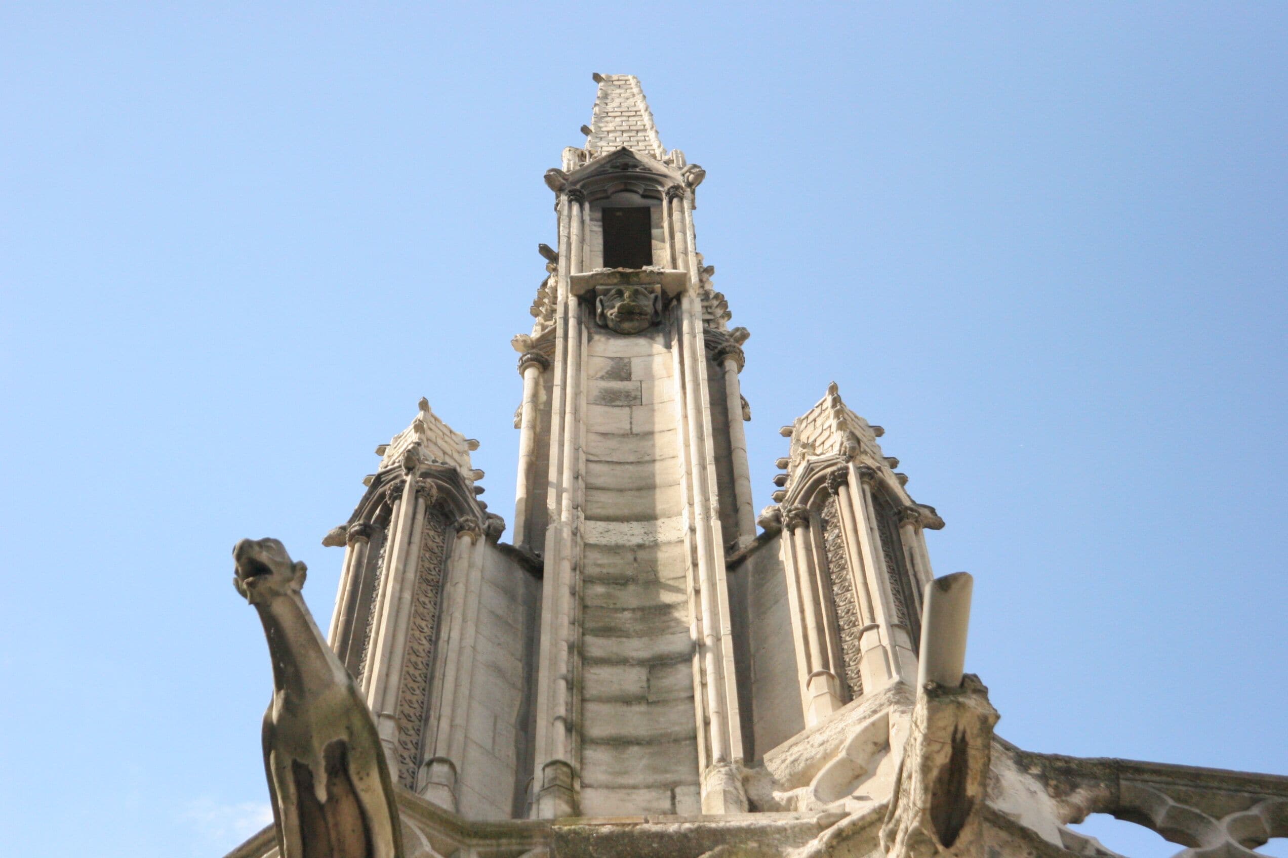 A Gothic-style tower with intricate stone carvings and a pointed spire.