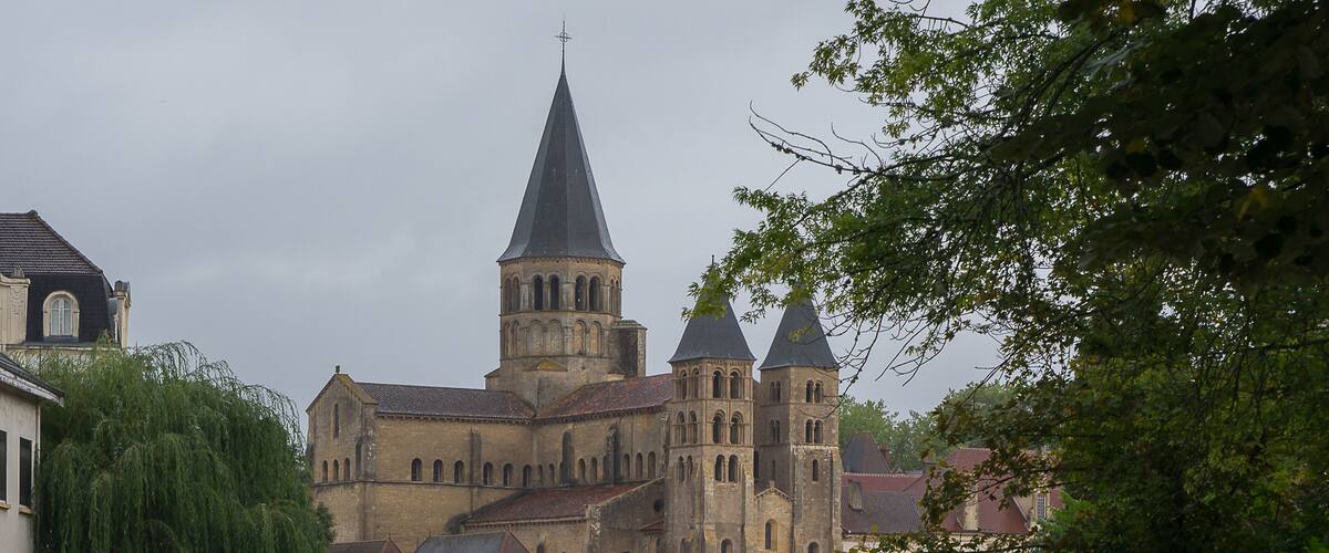 A historic cathedral with a prominent tower and a bridge over a river.