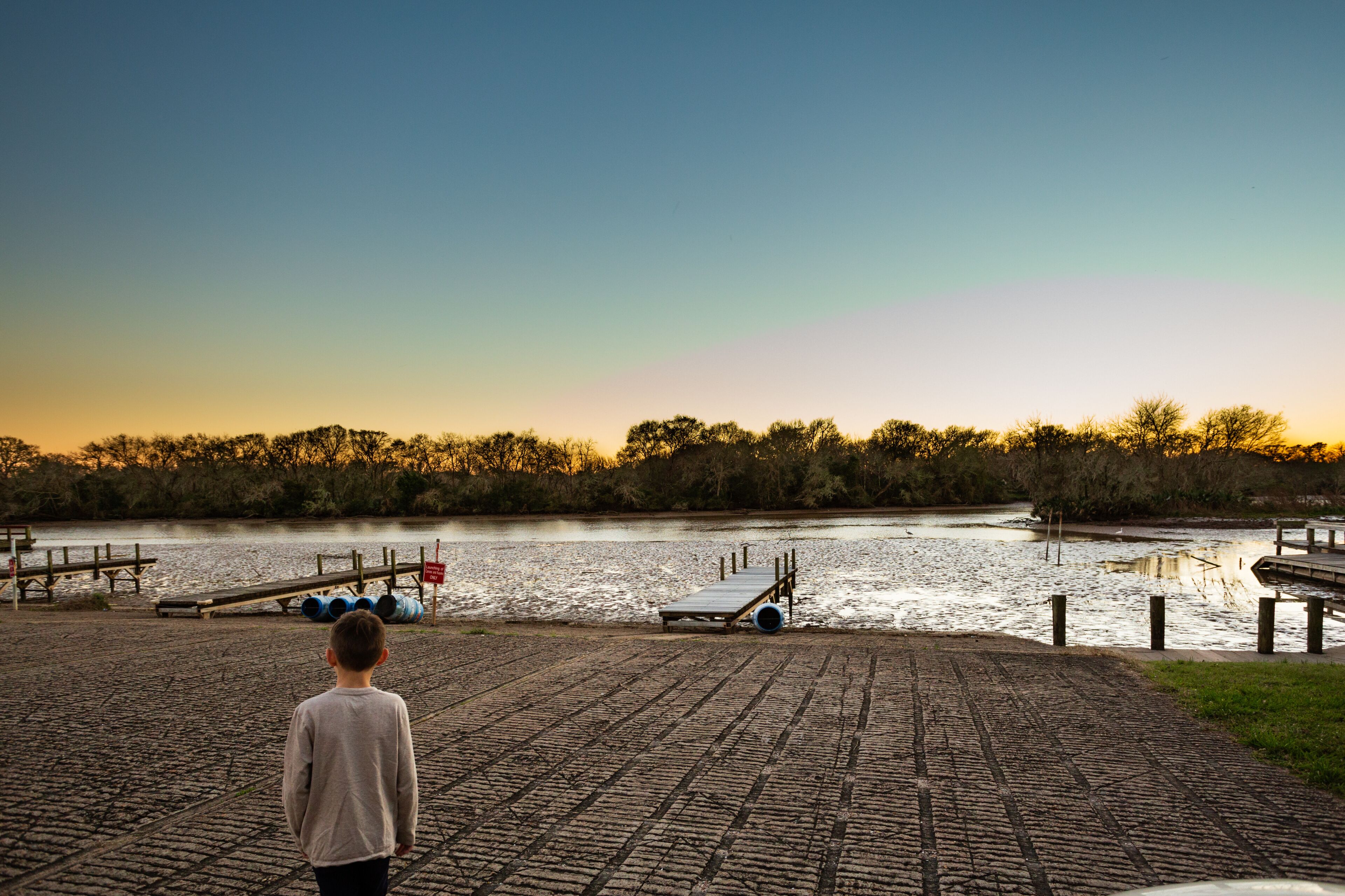 Young boy enjoying a clear sky and glowing sunset at the Clear Creek boat ramp