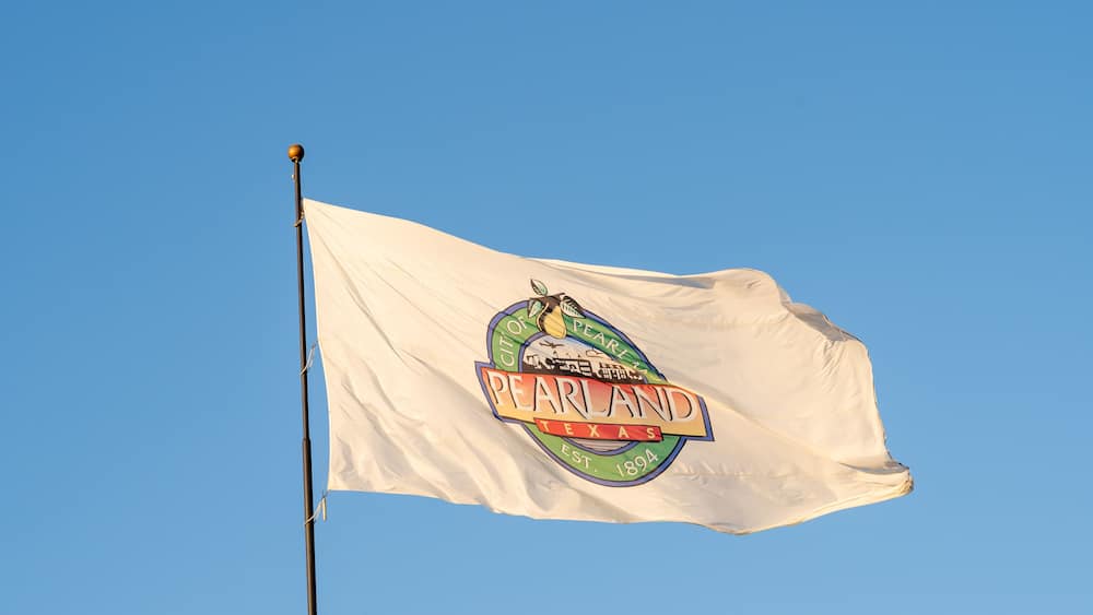 Flag of Pearland waving in the wind with blue sky in background. Pearland is a city in the U.S. state of Texas.