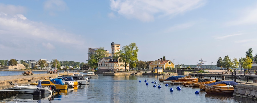 Um porto com barcos, uma torre e edifícios ao longo da orla.