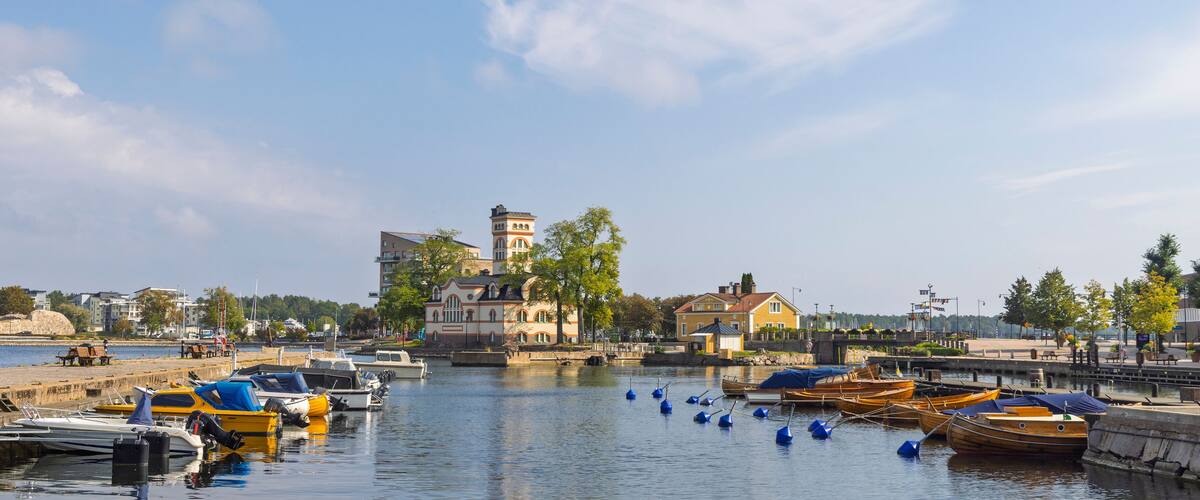 A harbor with boats, a tower, and buildings along the waterfront.