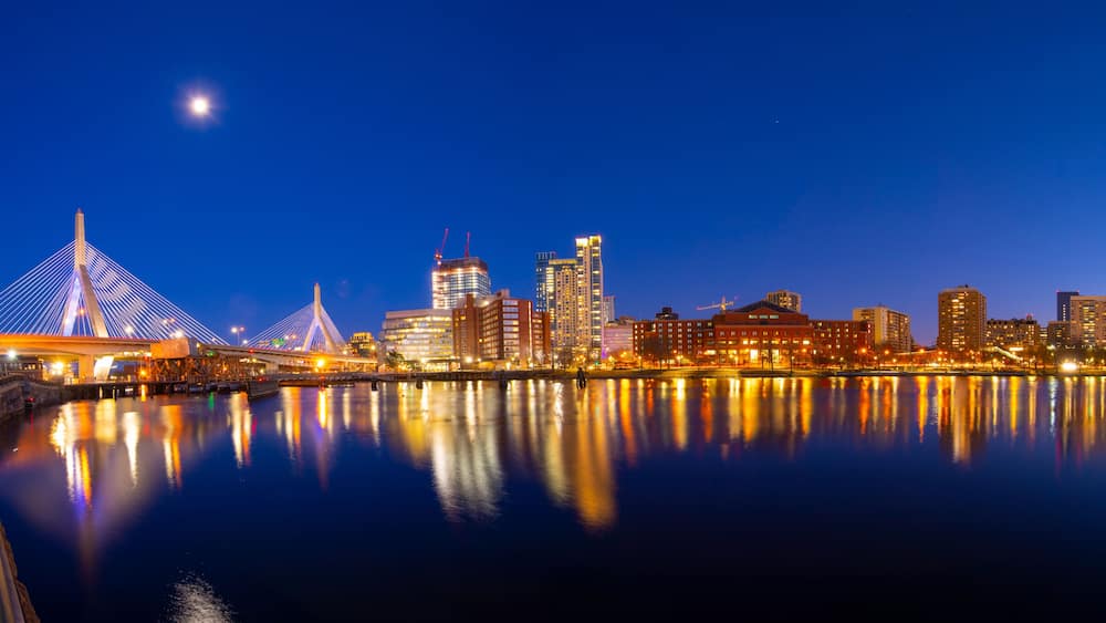 Boston Leonard P. Zakim Bunker Hill Memorial Bridge and Charles River panorama at night with twilight, Boston, Massachusetts MA, USA.