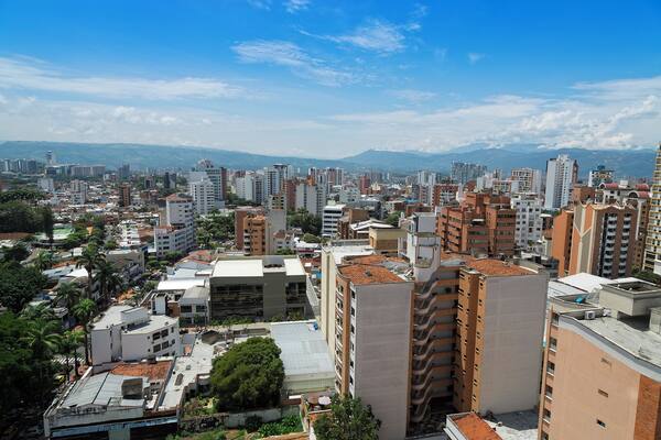 Colombia, Bucaramanga city. Panoramic View, buildings and vegetation. Overview of buildings, behind the buildings there are mountains and clear sky.