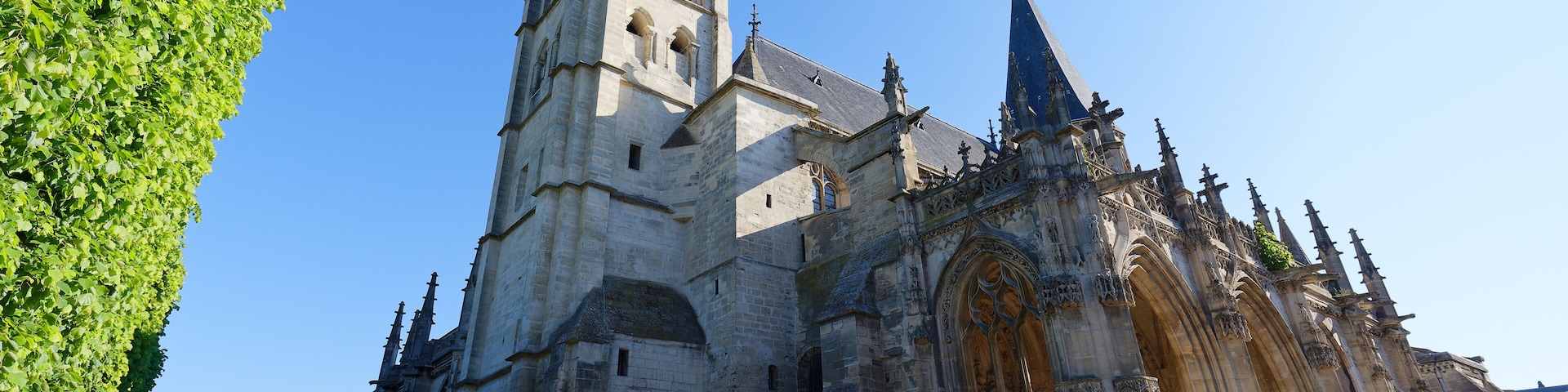 Una catedral histórica con un alto campanario y arquitectura gótica detallada.