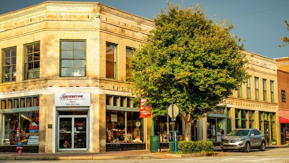 A corner building with Cornerstone Antique & Craft Market, a Coors Light sign, and a parked car.