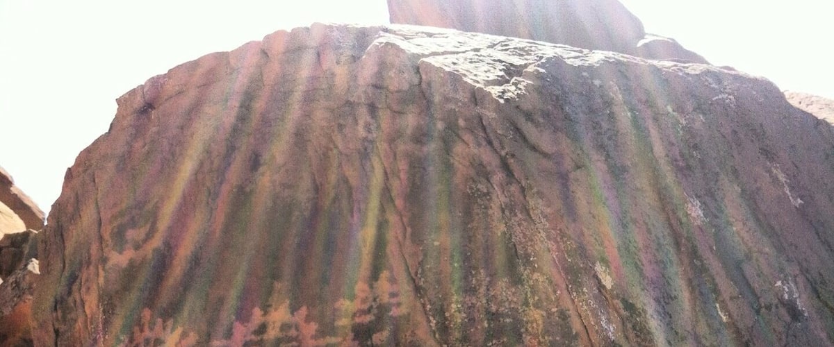 A large rock with visible carvings and natural striations.