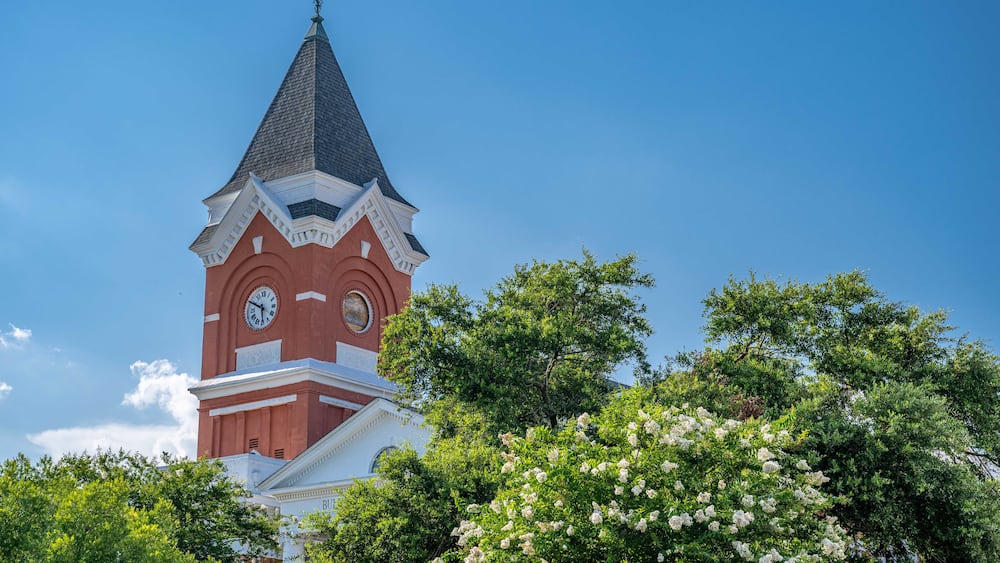 A church with a clock tower and a steeple under a clear blue sky.