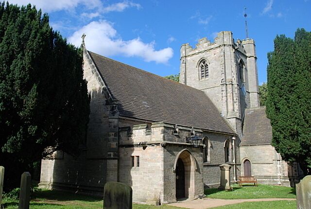A stone church with a tall bell tower and arched entrance.