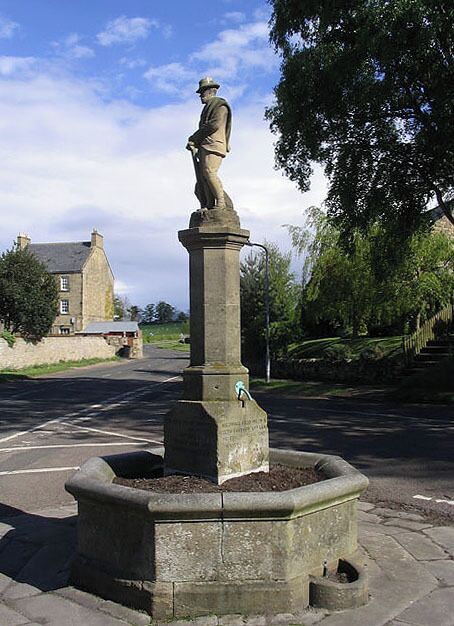 Fountain memorial in Whittingham A one time drinking fountain now filled in ready for bedding plants. Dedicated to the memory of the Third Earl of Ravensworth. There are four inscriptions at the base of the column as follows:- TO THE DEAR MEMORY OF ATHOLE THIRD EARL OF RAVENSWORTH HE SHALL FEED ME IN A GREEN PASTURE AND LEAD ME FORTH BESIDE THE WATERS OF COMFORT PS X111.11 ERECTED BY HIS WIFE CAROLINE COUNTESS OF RAVENSWORTH THE LORD IS MY SHEPHERD I SHALL NOT WANT PS. XX111.1