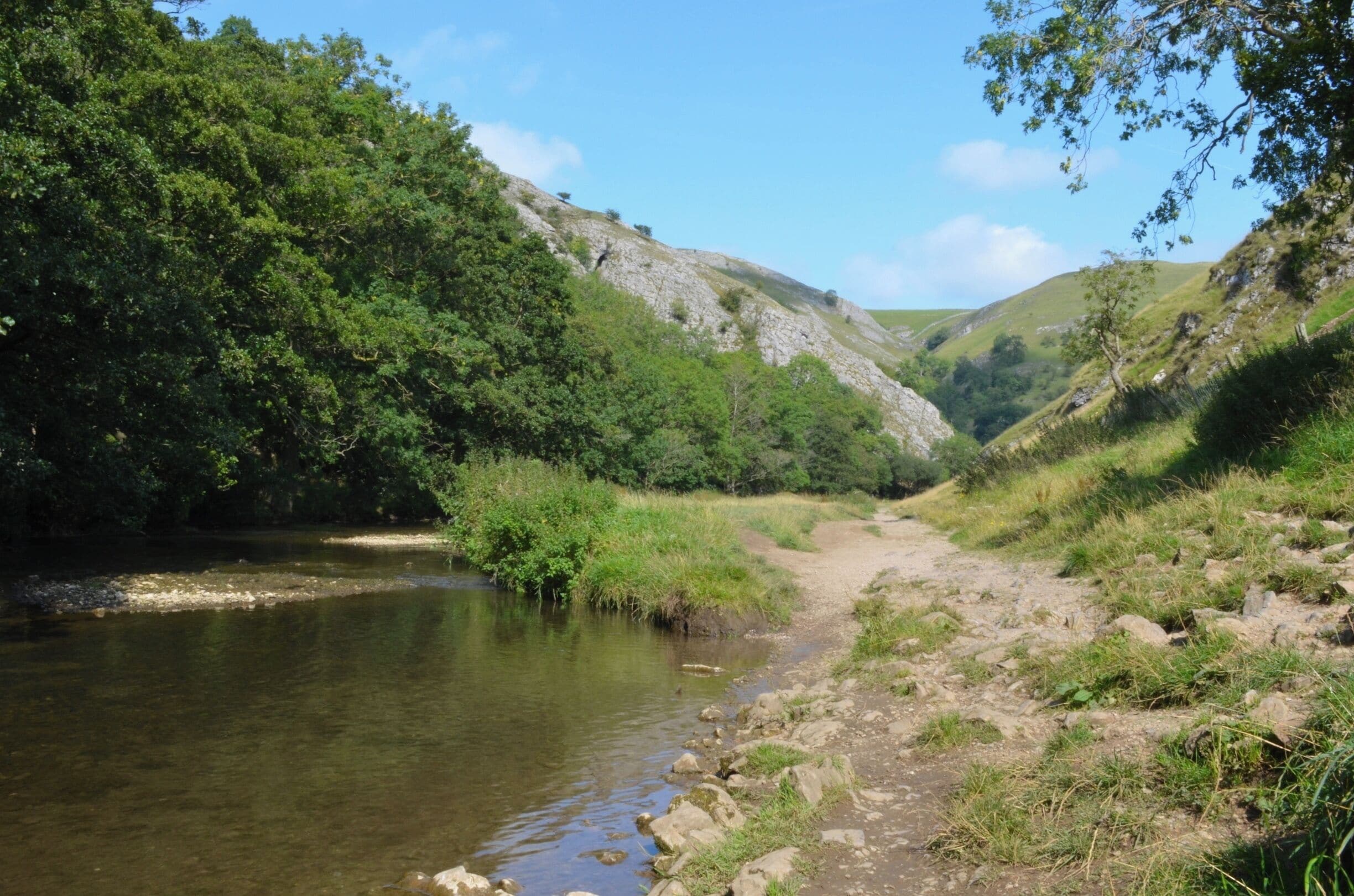 A river flowing through a valley with rocky terrain and dense green foliage.