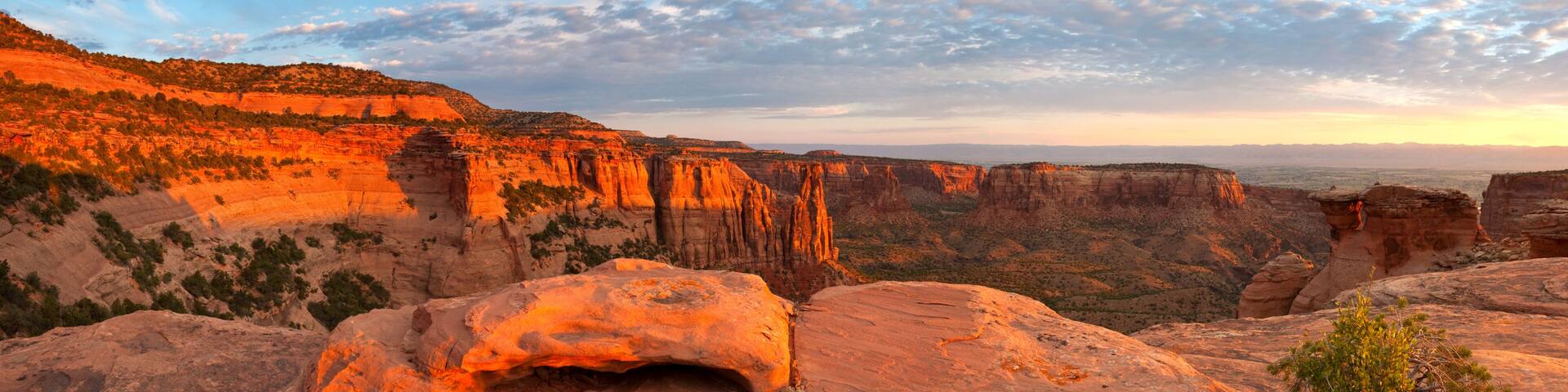A canyon with layered rock formations and a clear sky.