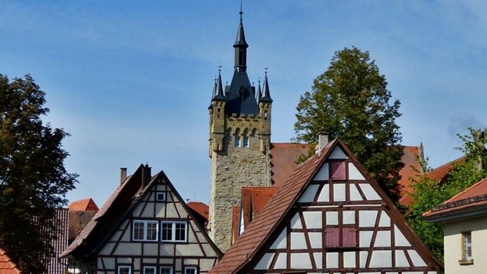 A historic town with timber-framed houses and a prominent church tower.