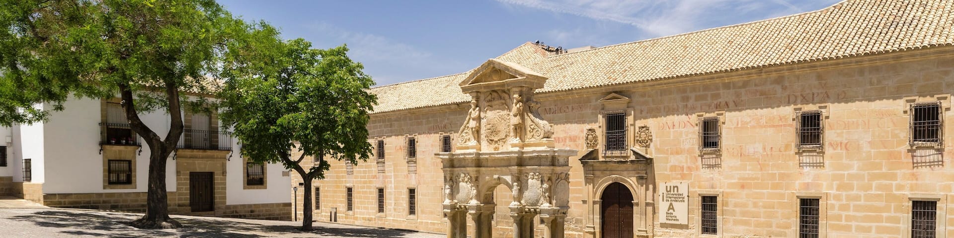 A historic building with a courtyard, a fountain, and a tree.