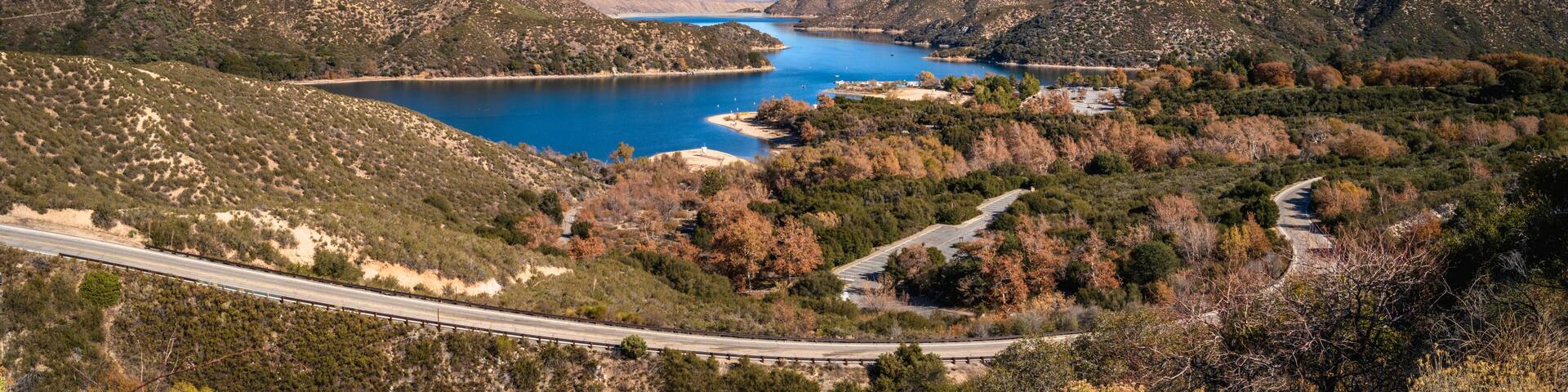 Tranquil autumn forest lake landscape with curving paved road at Silverwood Lake along Rim of the World Scenic Drive in San Bernardino National Forest, California