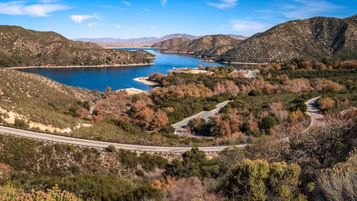 Tranquil autumn forest lake landscape with curving paved road at Silverwood Lake along Rim of the World Scenic Drive in San Bernardino National Forest, California