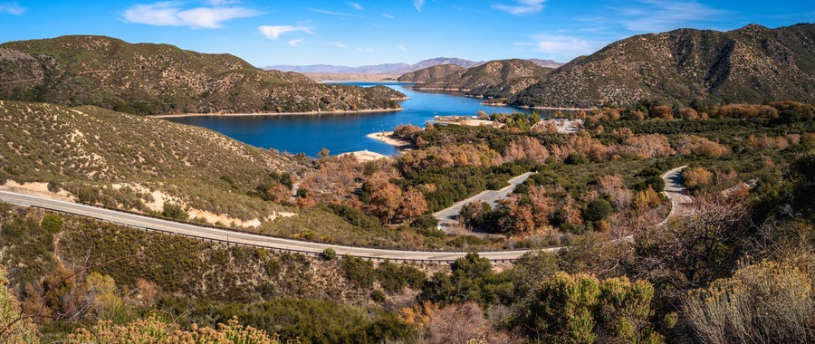 Tranquil autumn forest lake landscape with curving paved road at Silverwood Lake along Rim of the World Scenic Drive in San Bernardino National Forest, California