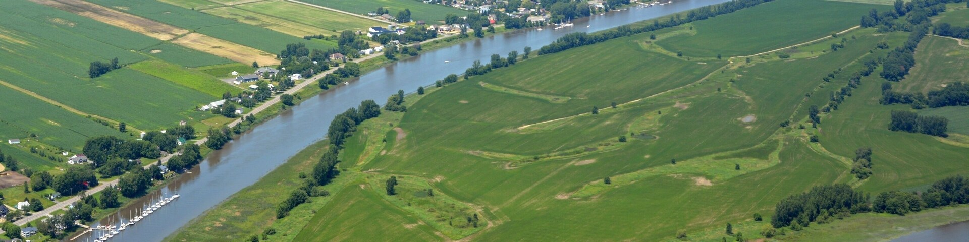 Summer scenic aerial view of the farmland on L`Ile aux Castors in the Saint Lawrence River, Berthierville in the background; Quebec Canada