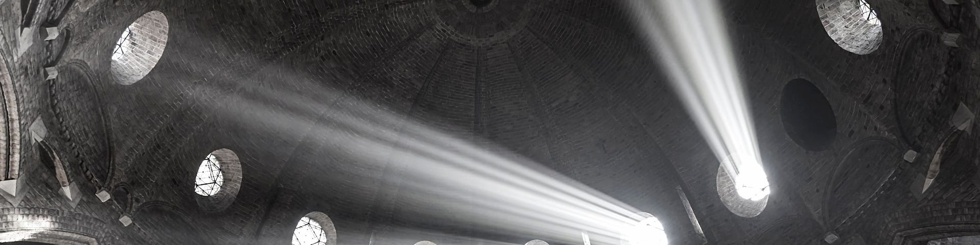 A cathedral interior with multiple arched windows and a central dome.