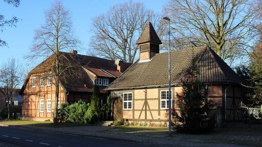 Links ist das Wohnhaus Grüne Allee 15 und rechts die Kapelle zu sehen. Beides sind Baudenkmale in Ramlingen.