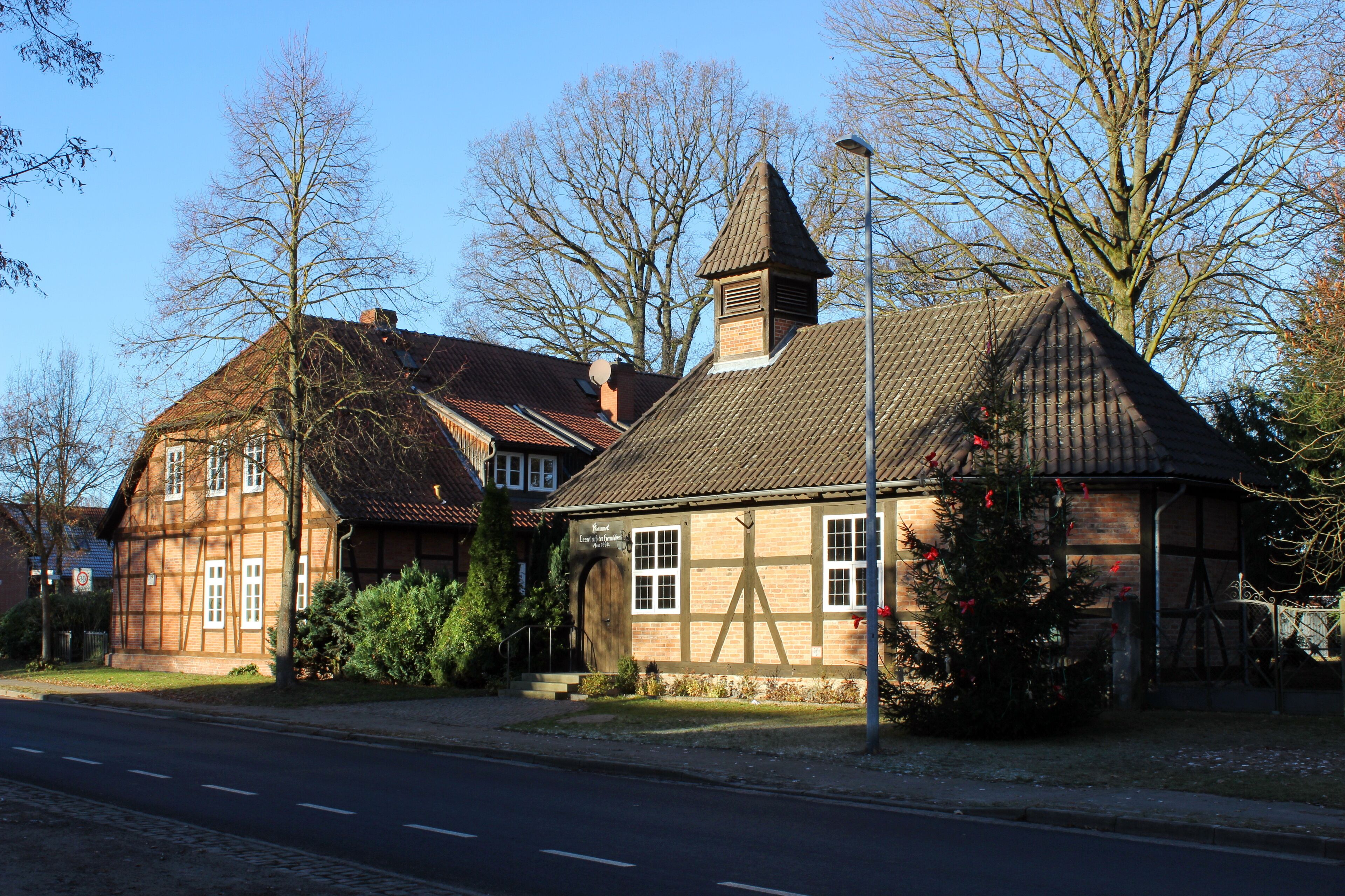 A traditional half-timbered house with a steeply pitched roof and a small tower.