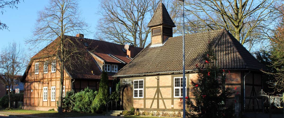 A traditional half-timbered house with a steeply pitched roof and a small tower.