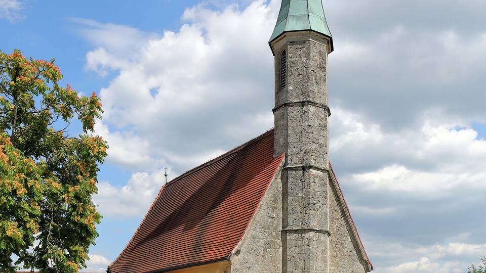 A church with a tall steeple and a red-tiled roof.
