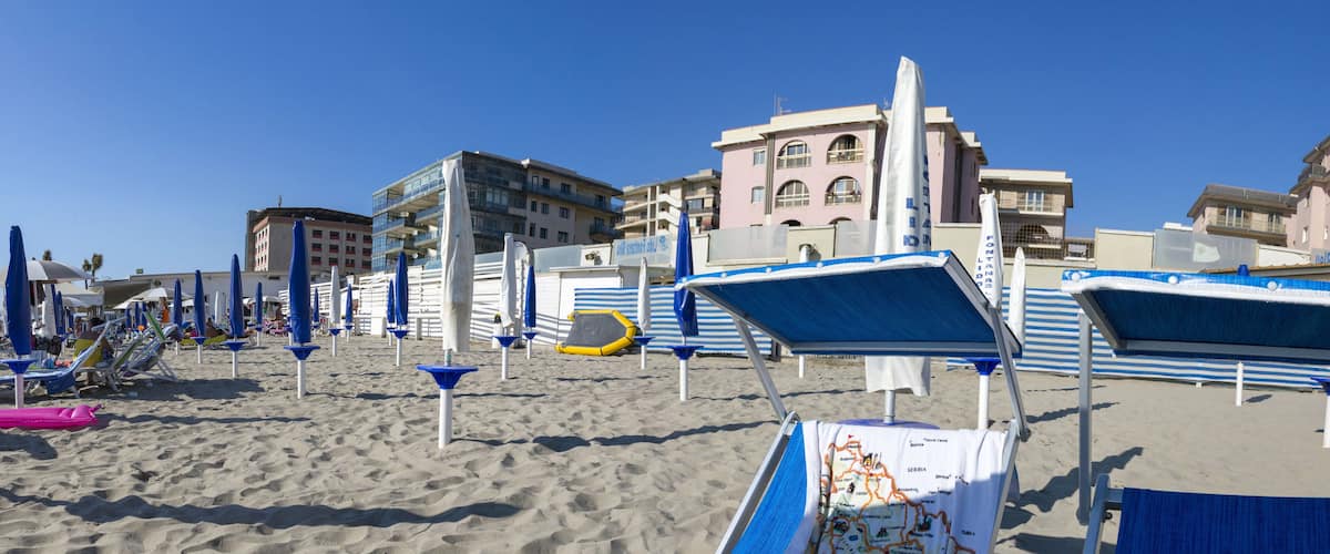 A beach with blue and white sun loungers, umbrellas, and a map of Serbia.