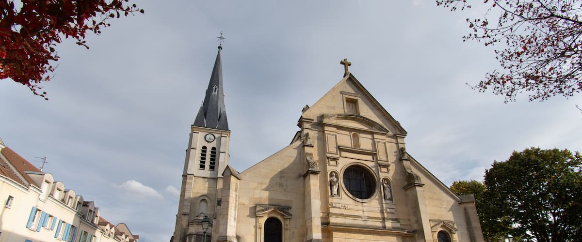 A historic church with a tall steeple and a red door.