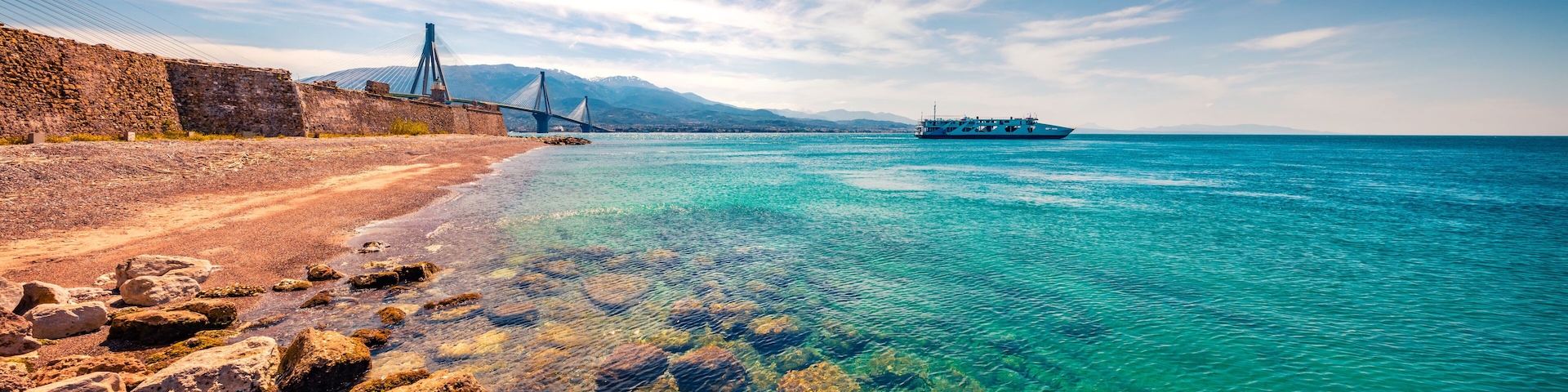 Panoramic morning view of Gulf of Corinth, Greece, Europe. Splendid spring scene of Rion-Antirion Bridge and ferryboat. Traveling concept background.