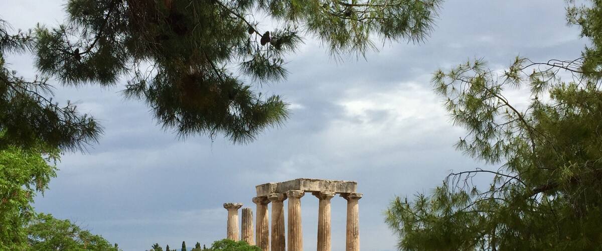 Ancient ruins with columns, a pathway, and surrounding vegetation.