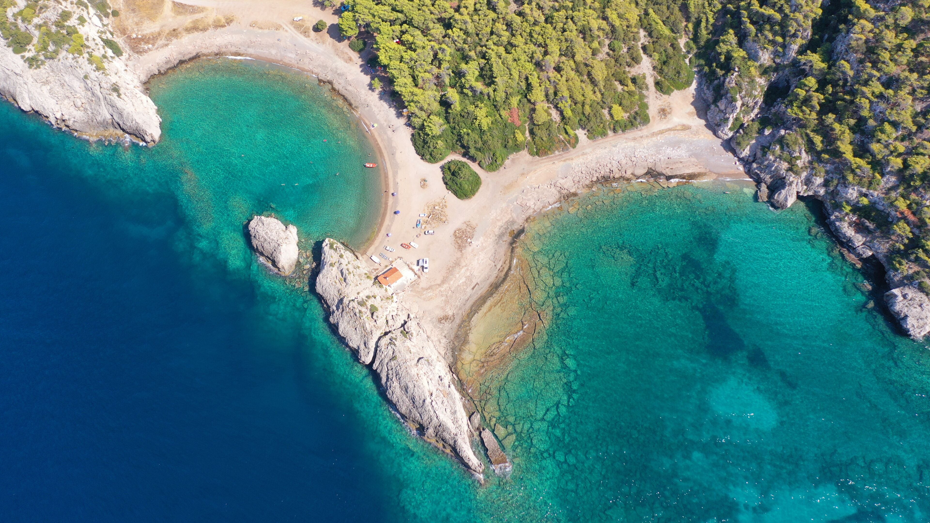 Aerial drone top down photo of scenic half moon shaped crystal clear sea beach of Milokopi near famous lake Vouiagmeni, Loutraki, Perachora, Greece